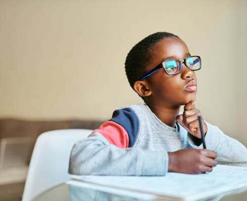 Shot of an adorable little boy doing his schoolwork at home