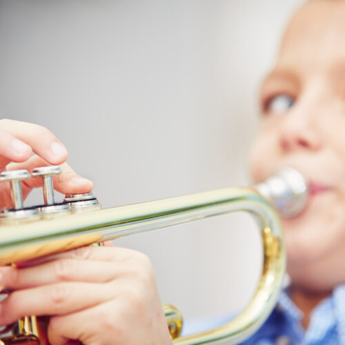 Little trumpeter - boy is playing the trumpet at home